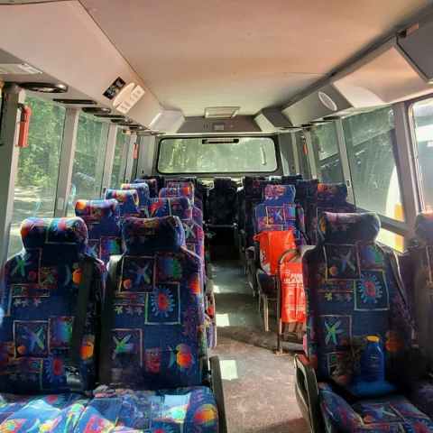 Interior of an empty tour bus with colorful patterned seats.