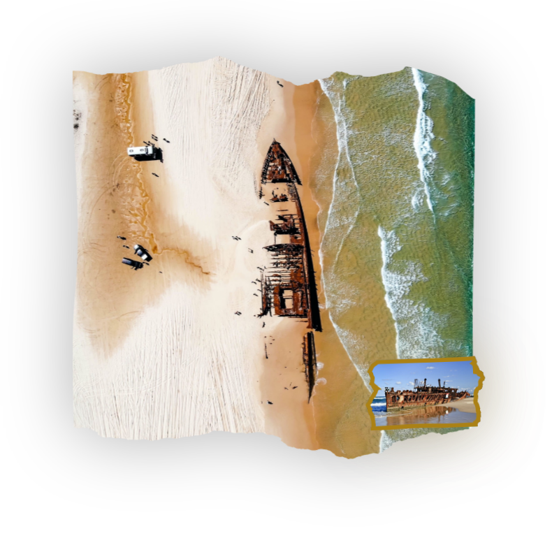 Aerial view of a shipwreck on a beach near ocean waves.